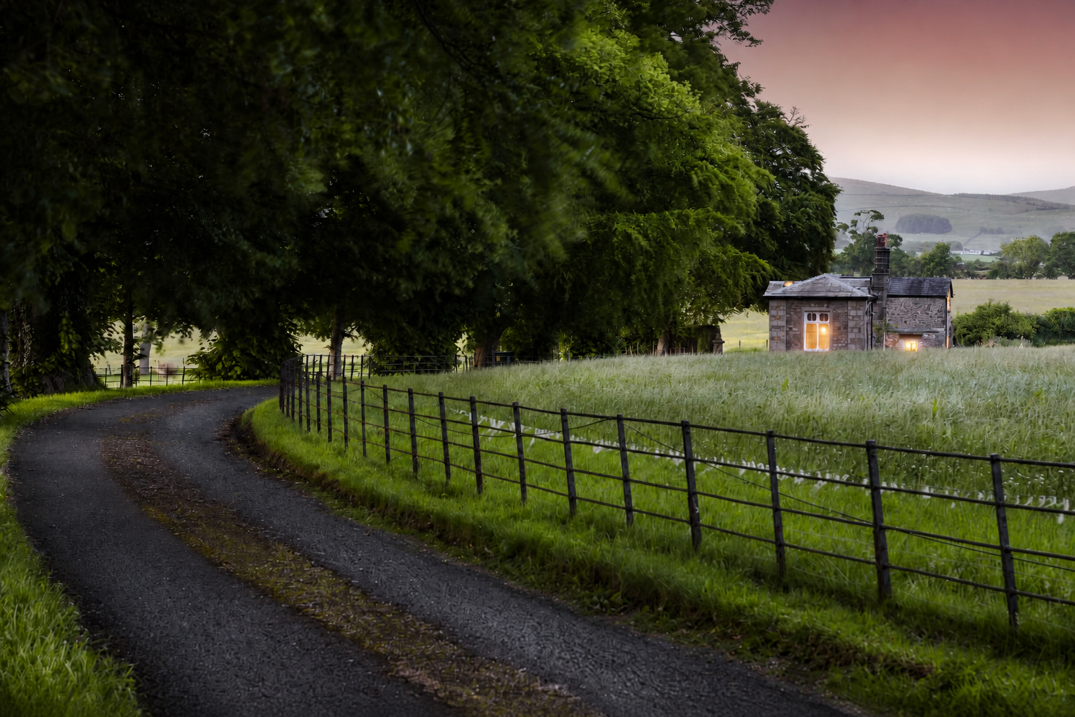A country lane curving through fields towards Summerfield Lodge